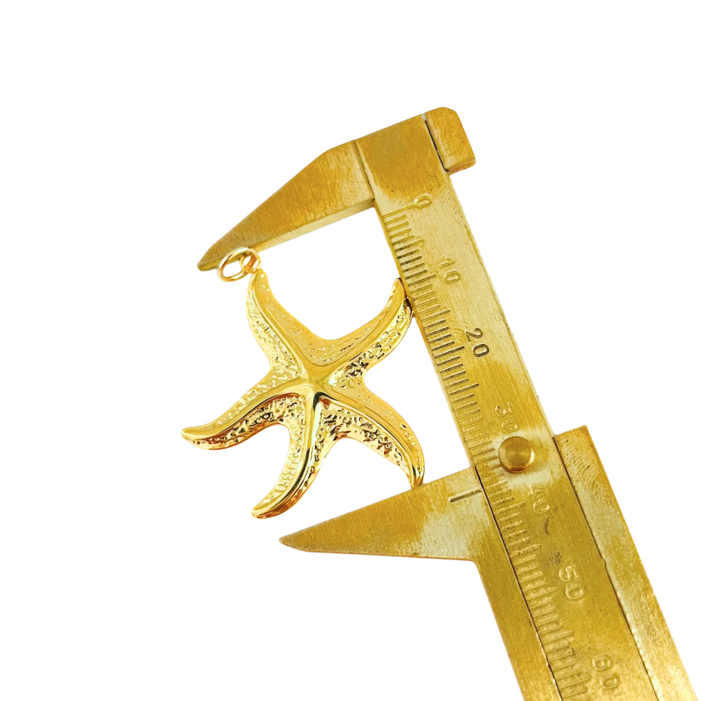 Gold starfish pendant being measured with a gold caliper on a white background