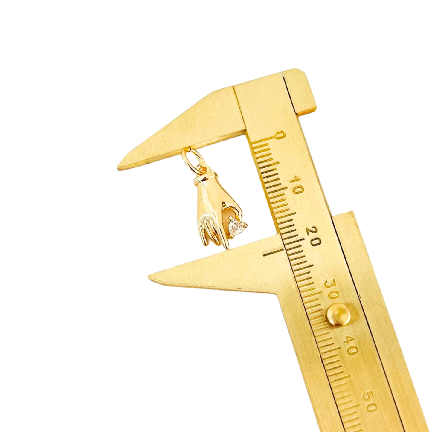 Gold caliper measuring Gold Plated Hand Heart CZ Pendant on a white back ground