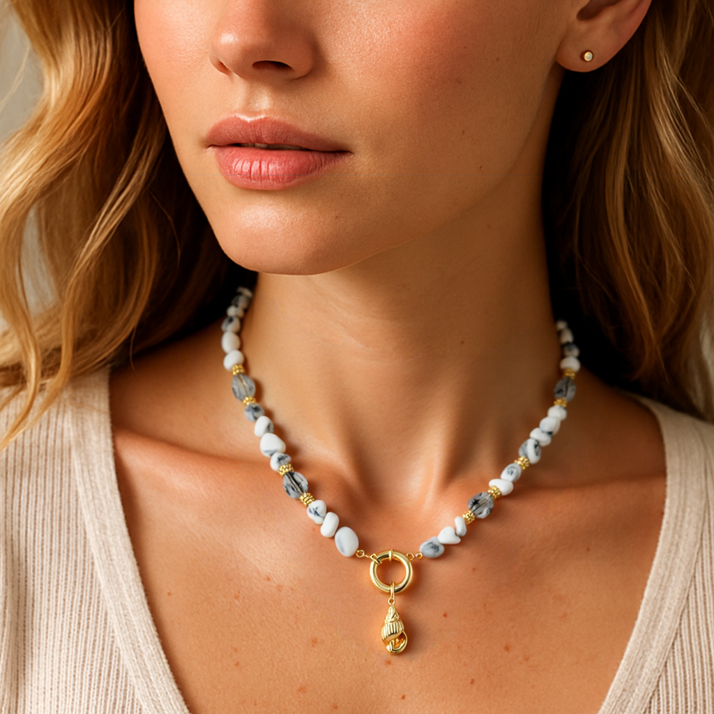 Woman wearing a necklace with a pendant against a neutral background