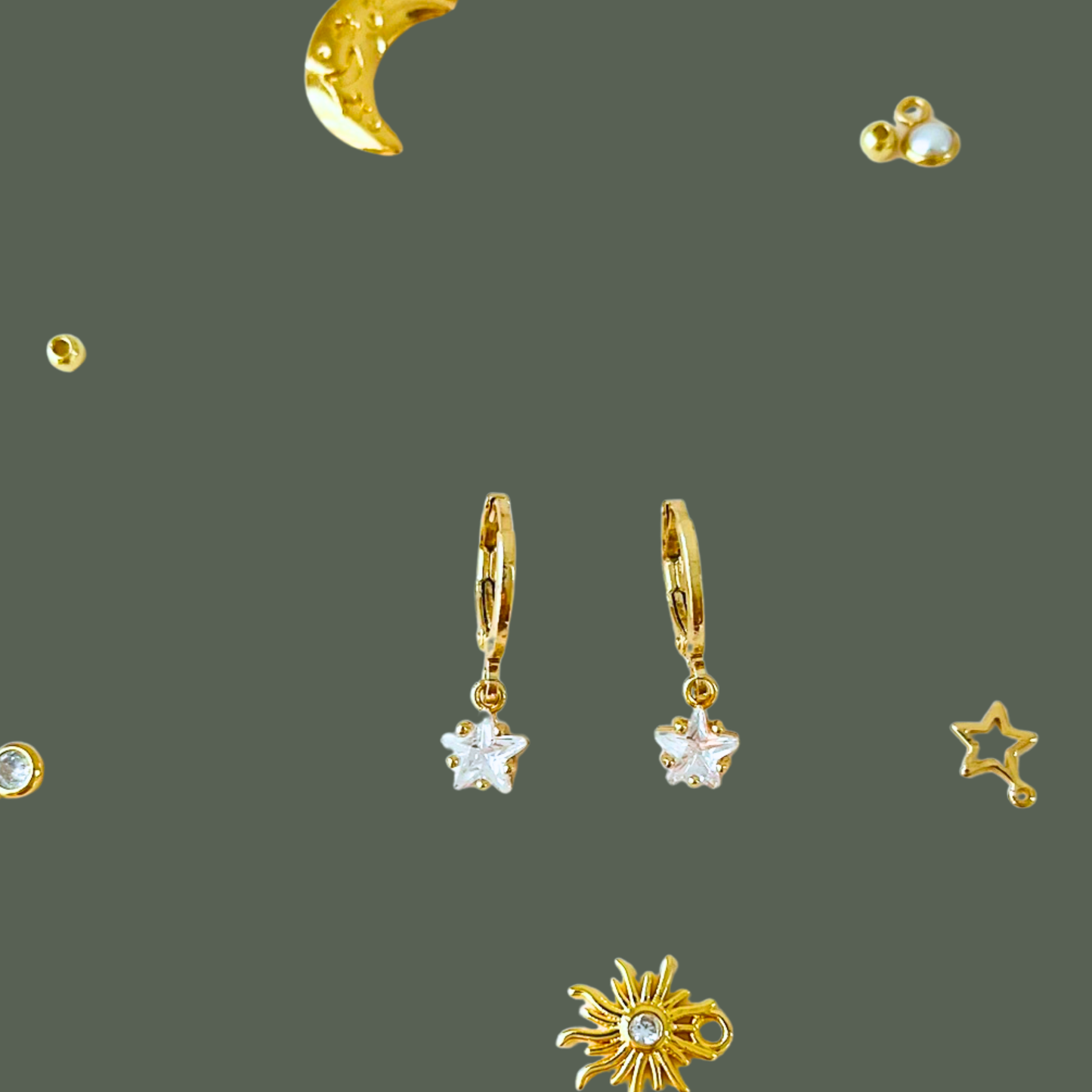 Gold earrings with star and moon designs on a dark gray background
