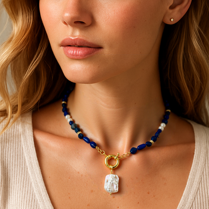 Woman wearing a necklace with a pendant against a neutral background