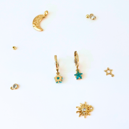 Collection of gold and turquoise jewelry charms on a white background