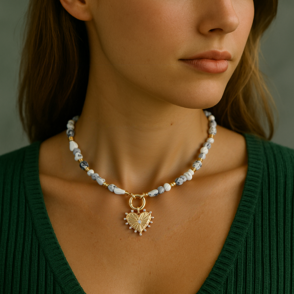 Woman wearing a necklace with a heart pendant against a neutral background
