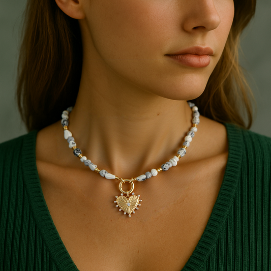 Woman wearing a necklace with a heart pendant against a neutral background