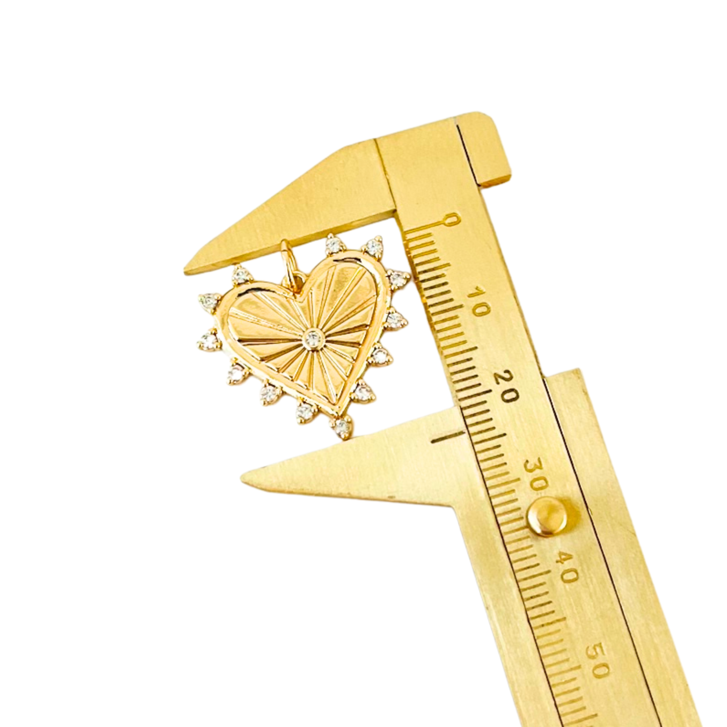 Gold heart-shaped pendant with a diamond being measured by a gold caliper on a white background