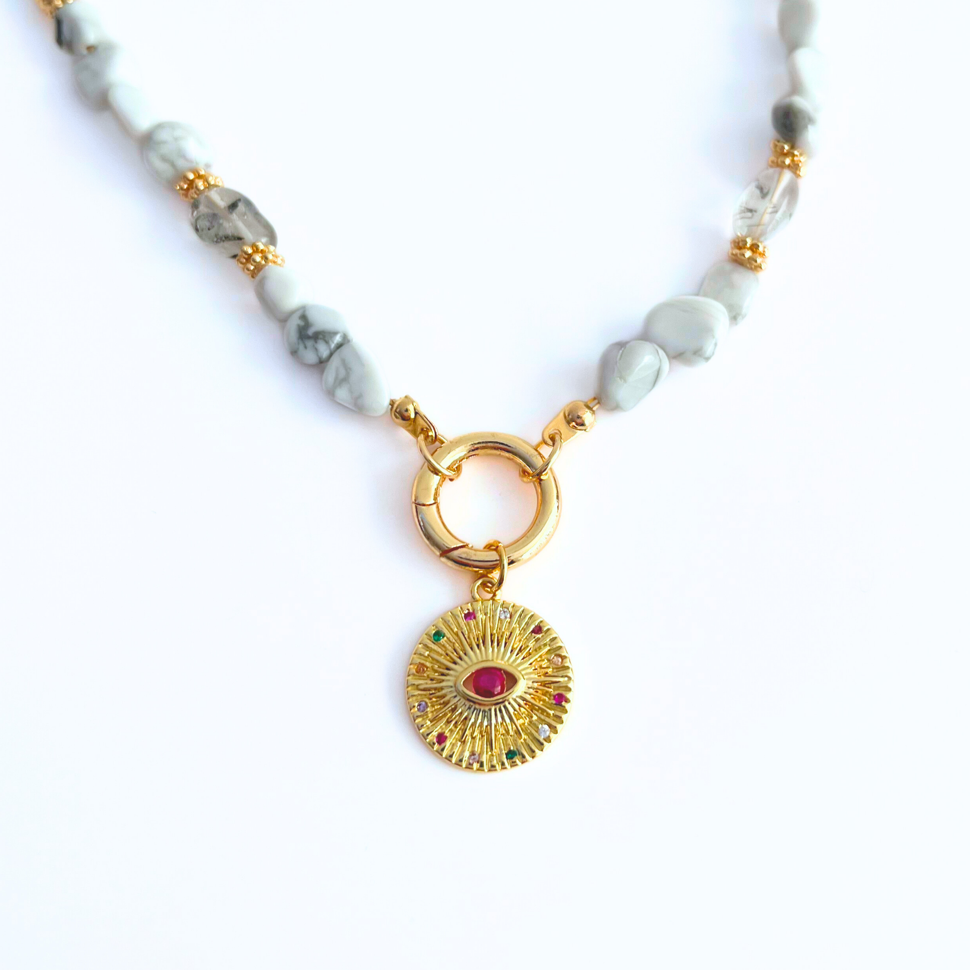 natural howlite gemstone Necklace with Magenta CZ Evil Eye Gold Plated Round Pendant on a white background