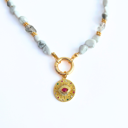natural howlite gemstone Necklace with Magenta CZ Evil Eye Gold Plated Round Pendant on a white background