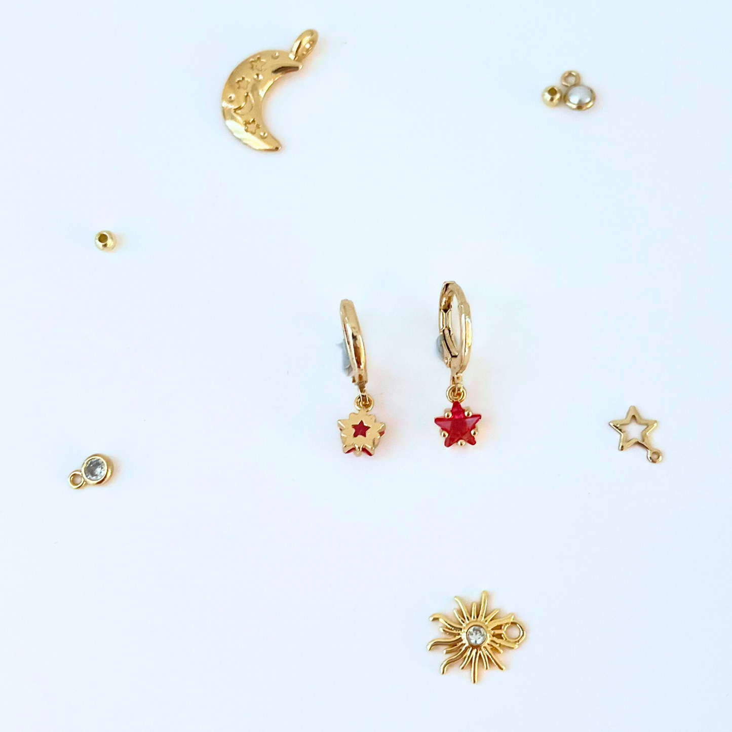Collection of gold and red earrings on a white background