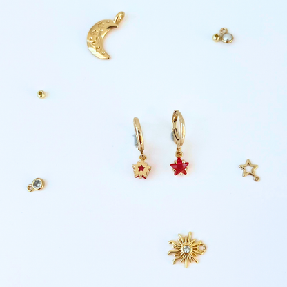 Collection of gold and red earrings on a white background