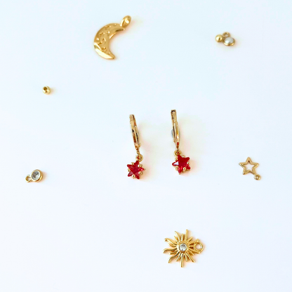 Gold and red jewelry charms on a white background