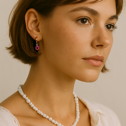 Woman wearing a necklace and earrings against a neutral background