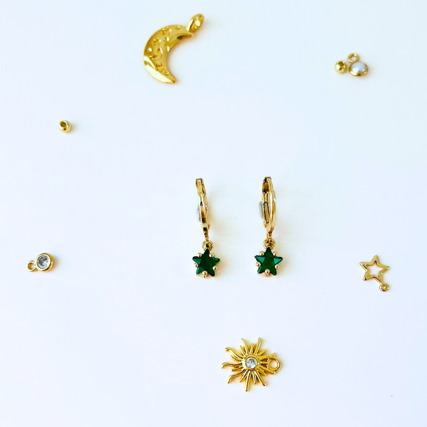 Collection of gold and green jewelry pieces on a white background