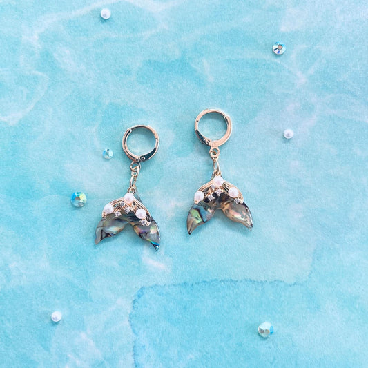 Pair of Mermaid Tail Earrings on a blue water textured background