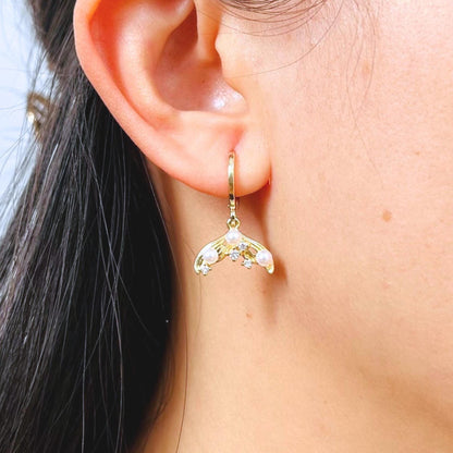 A Gold plated mermaid earring with CZ and pearls worn by a women