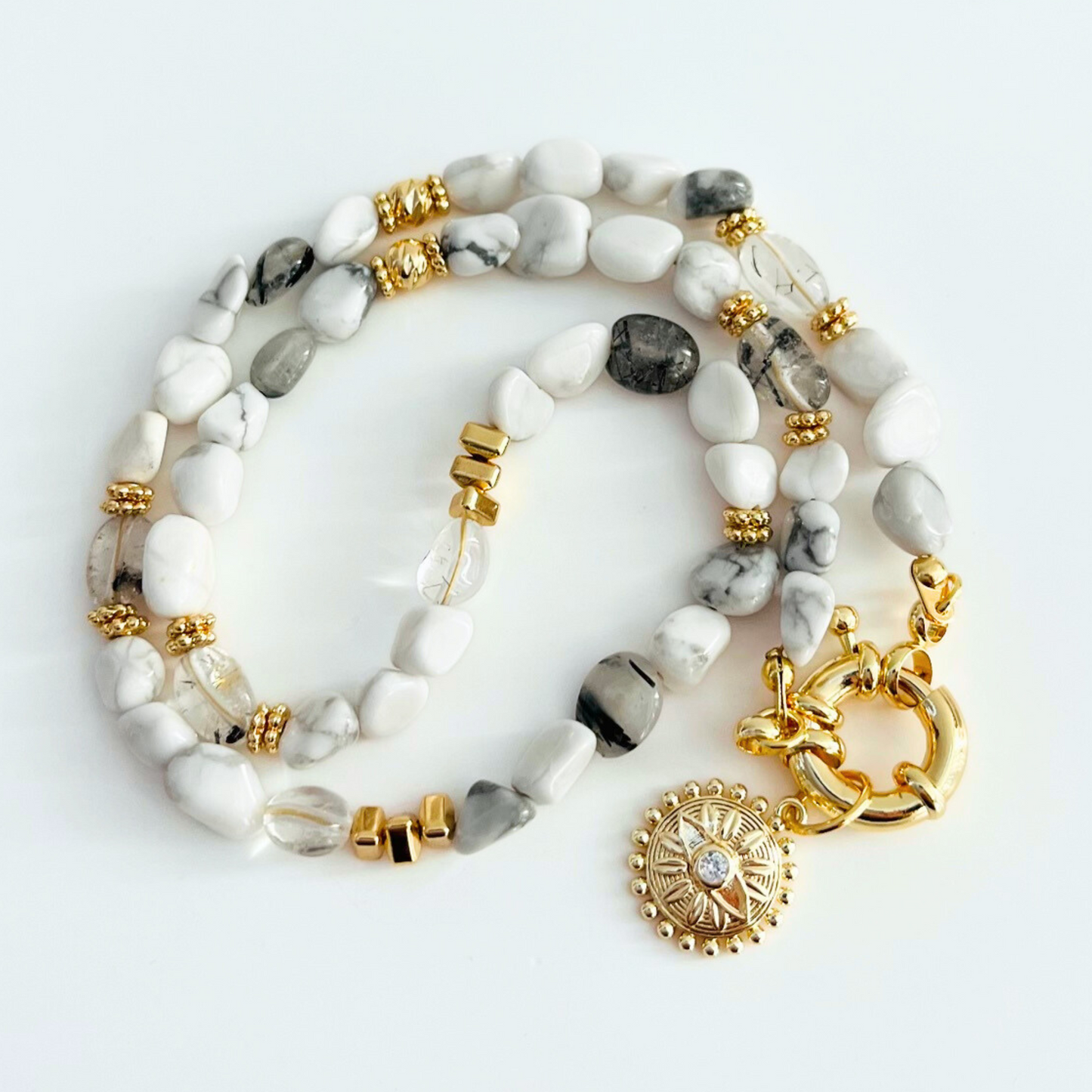 Natrual howlite gemstone necklace with Gold Plated Sunburst Evil Eye Pendant on a white background