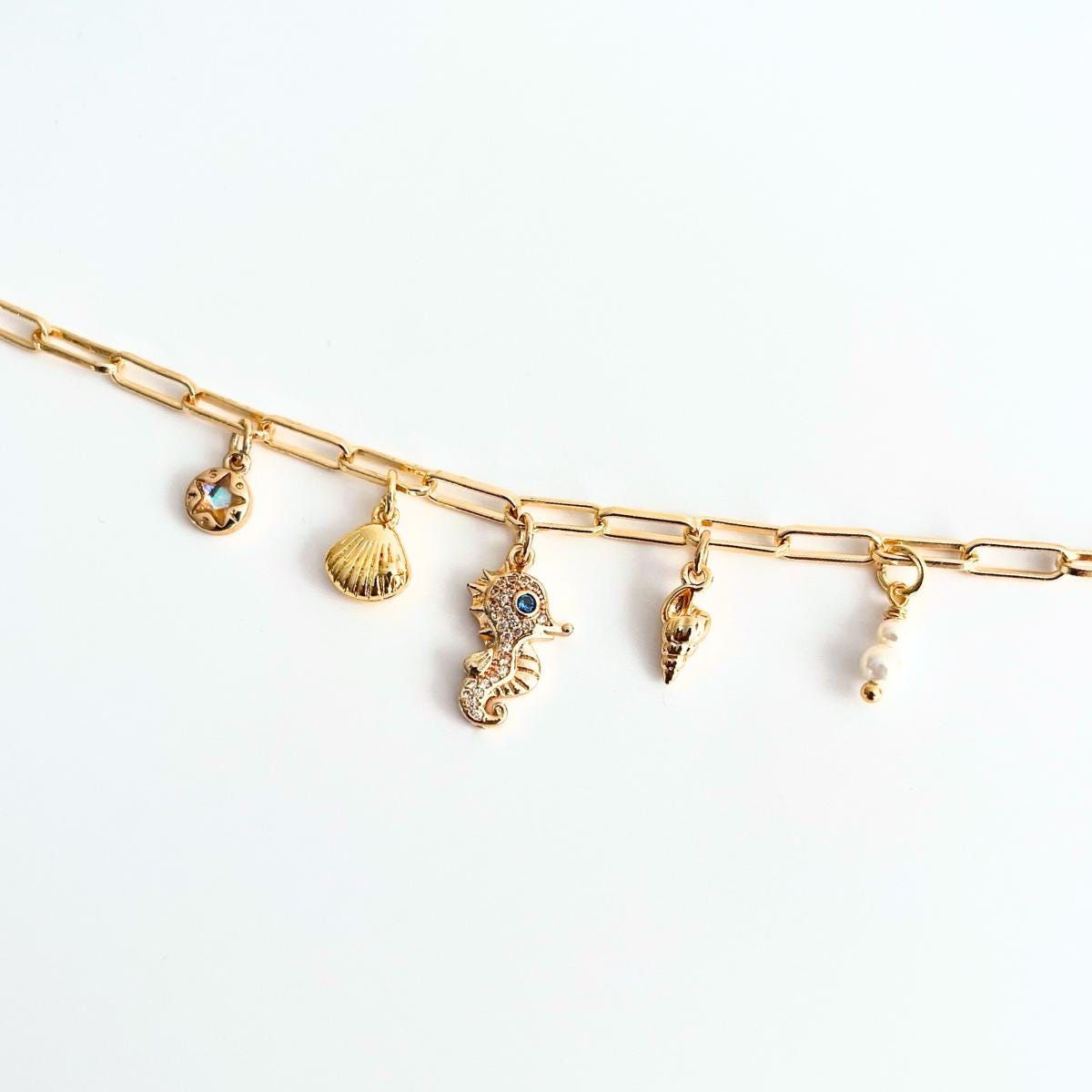Gold Plated Ocean Charm Shell Pearl  Seahorse bracelet on a white background