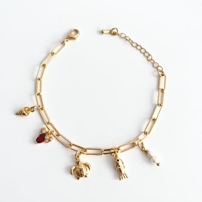 Gold plated Sea creatures bracelet with various charms on a white background